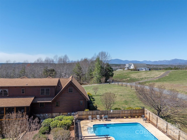 view of swimming pool featuring a fenced backyard, a fenced in pool, a mountain view, and a patio area