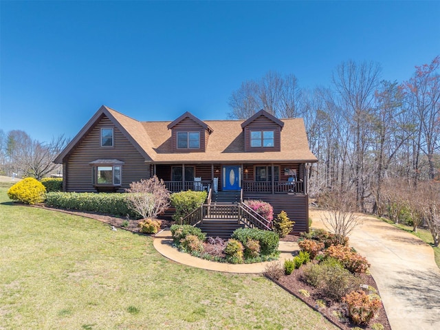 view of front facade featuring covered porch, a shingled roof, stairs, and a front lawn