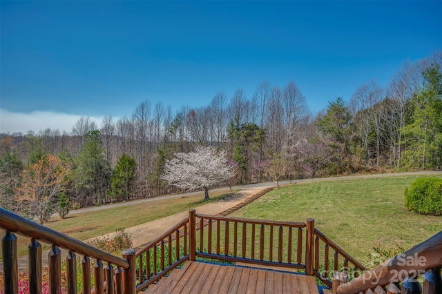 wooden deck with a lawn and a forest view