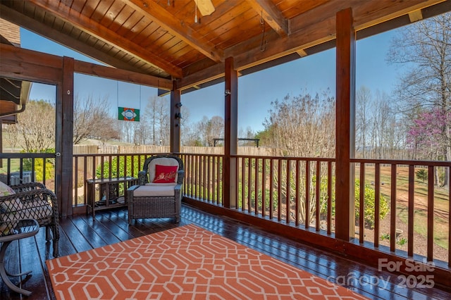 unfurnished sunroom with a wealth of natural light, ceiling fan, and beam ceiling