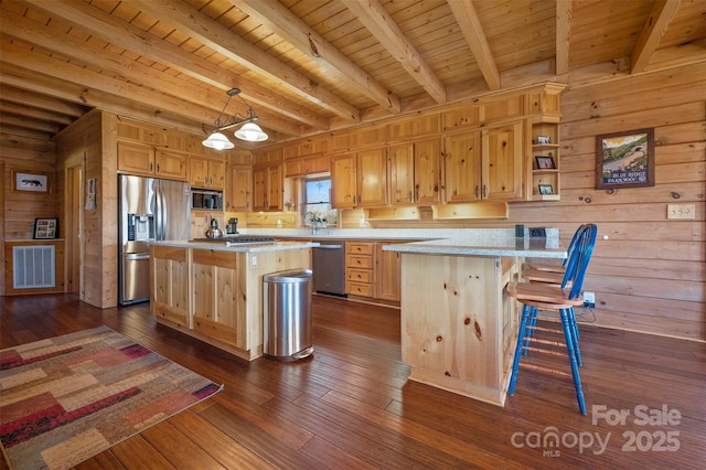 kitchen with light countertops, stainless steel appliances, light brown cabinetry, and visible vents