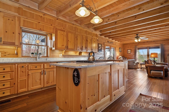 kitchen with dark wood-type flooring, a sink, wood ceiling, beam ceiling, and visible vents