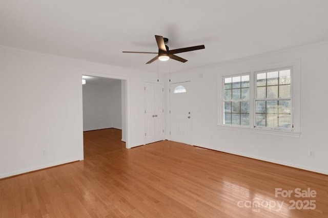 empty room featuring baseboards, wood finished floors, ceiling fan, and crown molding