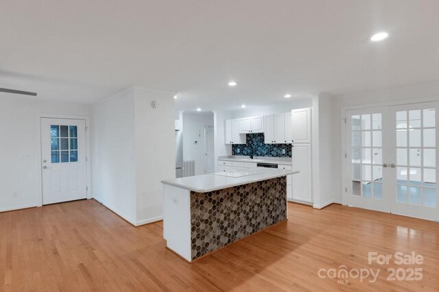 2750 Morgan Rd, Gold Hill, NC 28071 - kitchen featuring light wood-style flooring, freestanding refrigerator, light countertops, white cabinetry, and backsplash