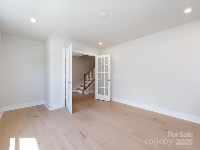 spare room featuring baseboards, french doors, wood finished floors, and recessed lighting
