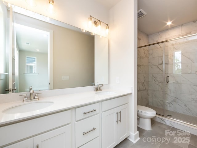 bathroom featuring visible vents, toilet, a marble finish shower, and a sink