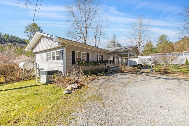 view of front of house with a front lawn and central AC