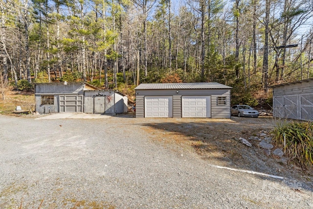 detached garage with a view of trees