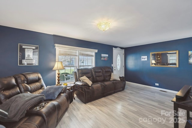 living room featuring baseboards and light wood-style flooring