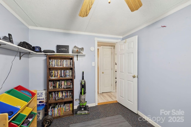 playroom with ornamental molding, baseboards, ceiling fan, and a textured ceiling