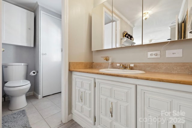bathroom with ornamental molding, toilet, tile patterned flooring, and vanity
