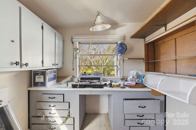 kitchen with built in desk, light countertops, and open shelves