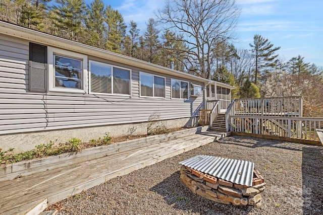 rear view of property with stairway and a deck