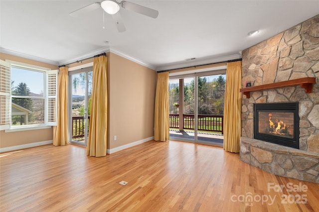 unfurnished living room featuring baseboards, crown molding, wood finished floors, and a fireplace