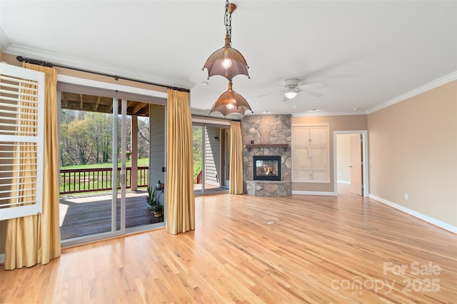 unfurnished living room featuring a ceiling fan, crown molding, a stone fireplace, light wood-type flooring, and baseboards