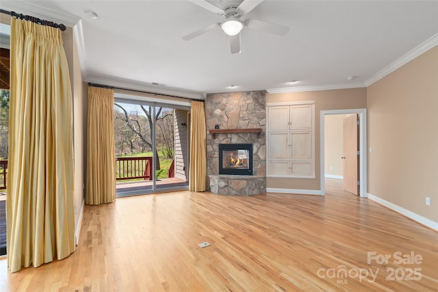 unfurnished living room featuring light wood finished floors, baseboards, ceiling fan, crown molding, and a fireplace