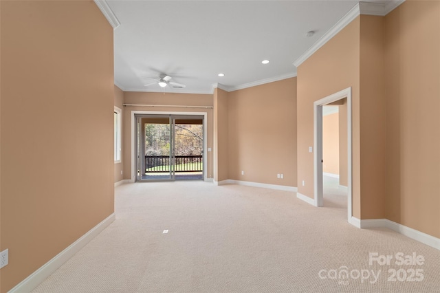 spare room featuring light colored carpet, ceiling fan, baseboards, and crown molding