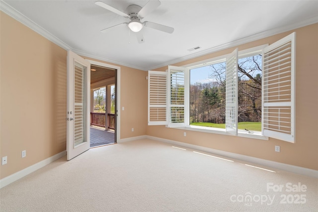 carpeted spare room with visible vents, crown molding, and baseboards