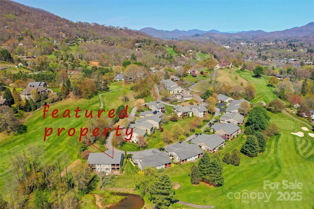 drone / aerial view with a residential view, a mountain view, and golf course view