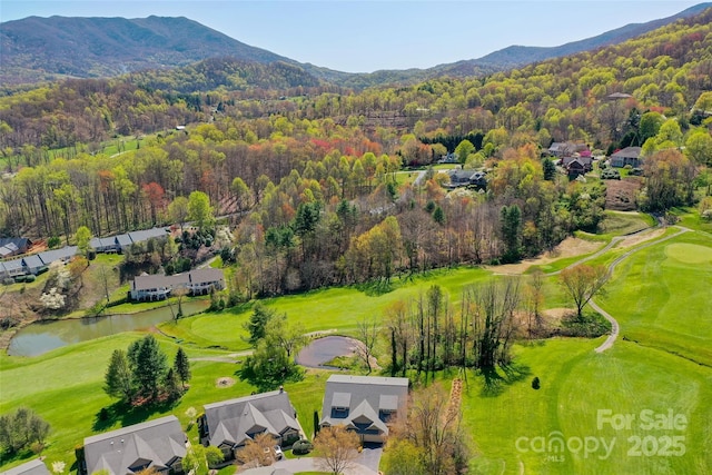 drone / aerial view featuring a water and mountain view, a residential view, golf course view, and a wooded view