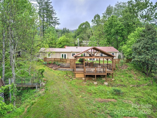731 Old Fort Rd, Fairview, NC 28730 - rear view of house with a wooden deck, a chimney, a forest view, and metal roof