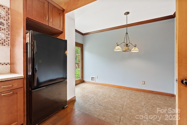 731 Old Fort Rd, Fairview, NC 28730 - kitchen with freestanding refrigerator, brown cabinetry, ornamental molding, baseboards, and light countertops