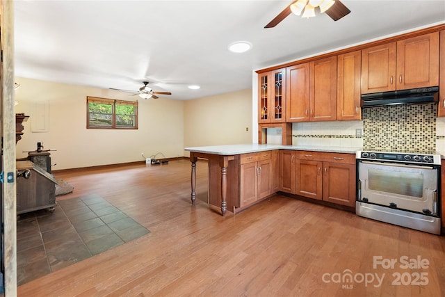 731 Old Fort Rd, Fairview, NC 28730 - kitchen featuring stainless steel electric range oven, ceiling fan, under cabinet range hood, and brown cabinetry
