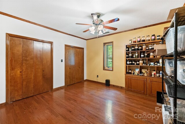 731 Old Fort Rd, Fairview, NC 28730 - unfurnished bedroom with two closets, wood finished floors, crown molding, and baseboards