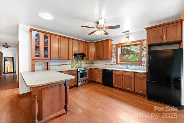 731 Old Fort Rd, Fairview, NC 28730 - kitchen with black appliances, under cabinet range hood, a ceiling fan, and brown cabinets
