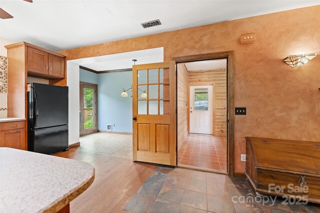 731 Old Fort Rd, Fairview, NC 28730 - kitchen with freestanding refrigerator, light countertops, brown cabinets, baseboards, and crown molding