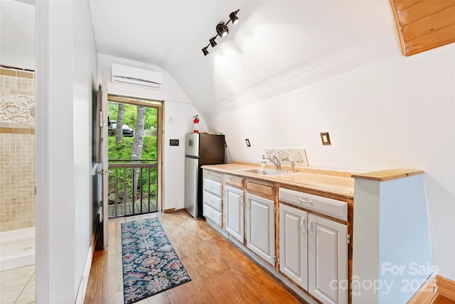 731 Old Fort Rd, Fairview, NC 28730 - kitchen featuring a sink, freestanding refrigerator, a wall mounted AC, vaulted ceiling, and light countertops