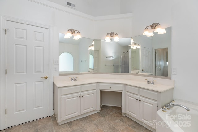 full bath with a sink, a shower with shower door, double vanity, and visible vents
