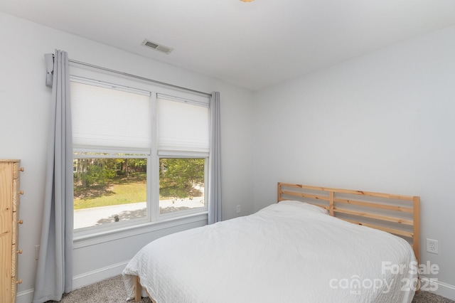 bedroom with visible vents, carpet flooring, and baseboards