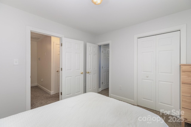 carpeted bedroom featuring baseboards and a closet
