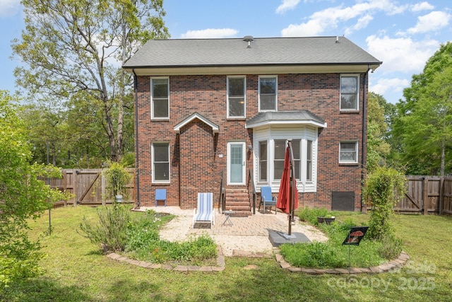 rear view of property featuring entry steps, a gate, a fenced backyard, a patio, and a yard