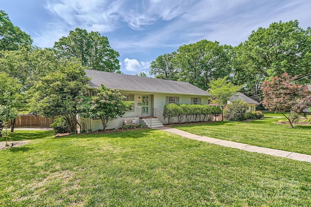 single story home featuring brick siding, a front lawn, and fence