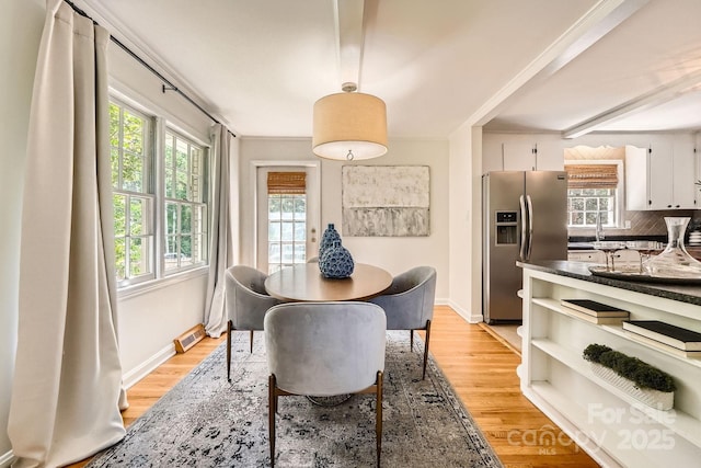 dining area with baseboards, visible vents, and light wood-style floors