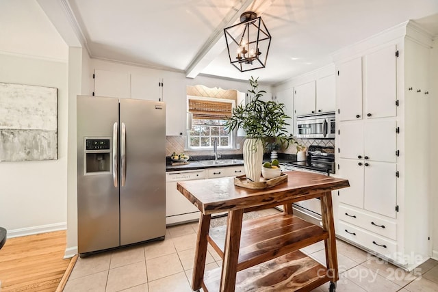 kitchen featuring backsplash, white cabinetry, stainless steel appliances, and a sink