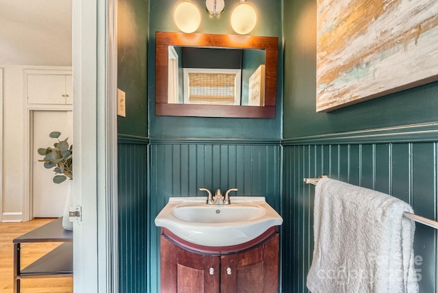 bathroom with wainscoting, vanity, and wood finished floors