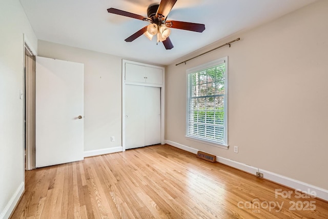 unfurnished bedroom with baseboards, a ceiling fan, light wood-style floors, and a closet