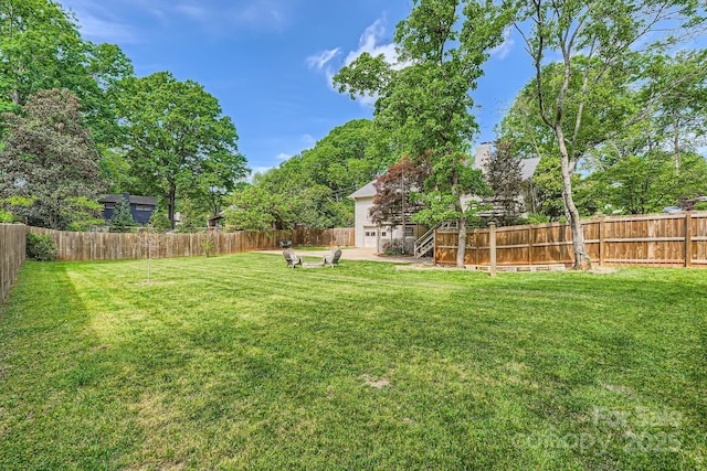 view of yard with stairs, a patio area, and a fenced backyard