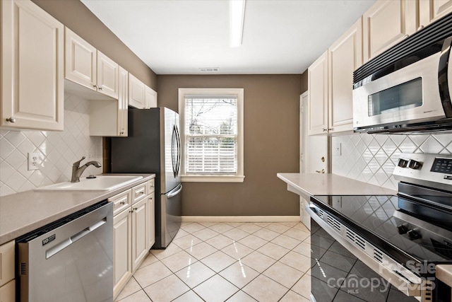 kitchen with visible vents, a sink, stainless steel appliances, light tile patterned flooring, and light countertops