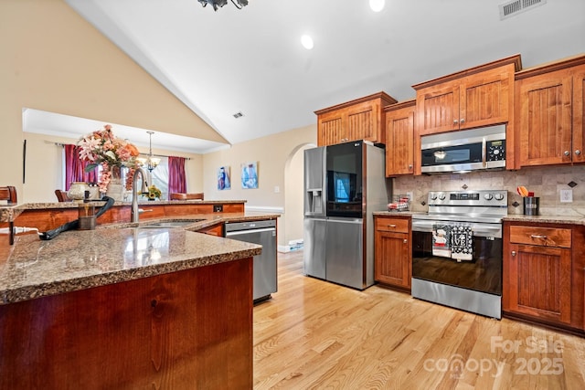 1263 Waterford Dr, Hickory, NC 28602 - kitchen featuring stainless steel appliances, a sink, light wood finished floors, backsplash, and high vaulted ceiling