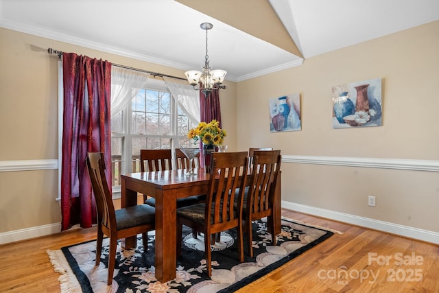 1263 Waterford Dr, Hickory, NC 28602 - dining area with a chandelier, baseboards, light wood finished floors, ornamental molding, and lofted ceiling