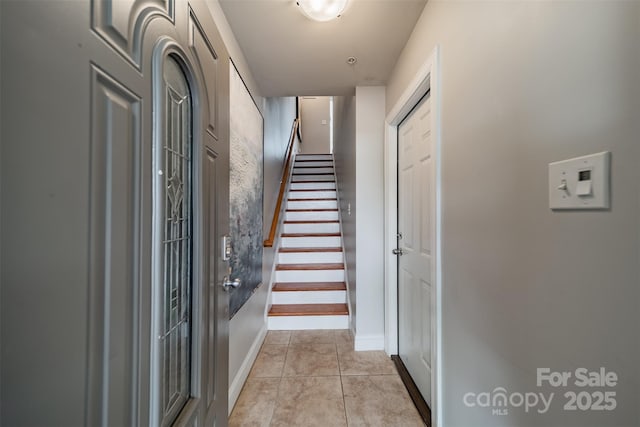 staircase featuring baseboards and tile patterned flooring