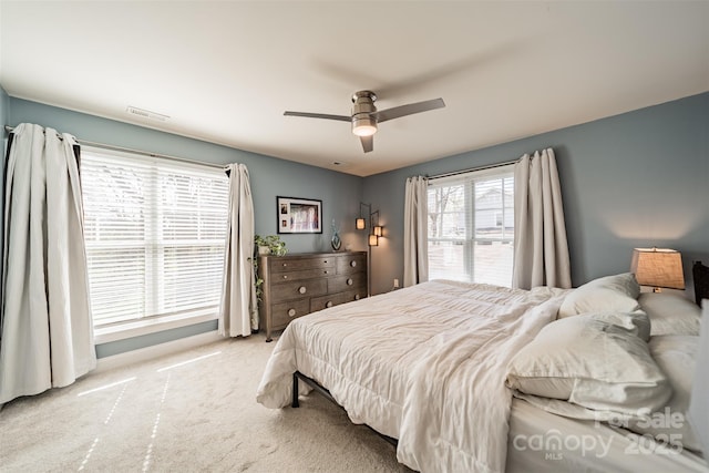 carpeted bedroom with visible vents and ceiling fan