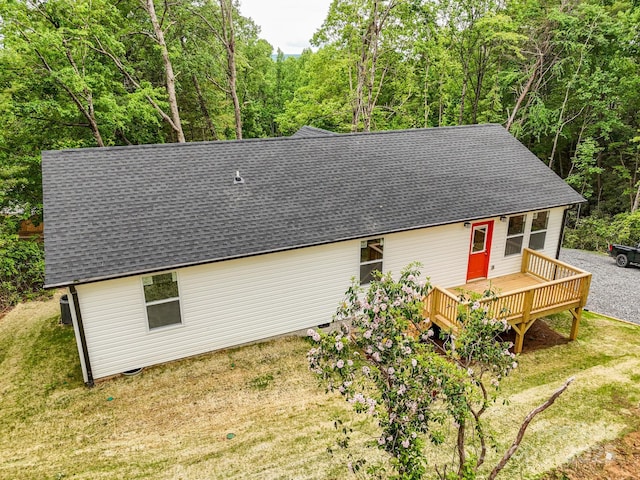 2506 Turnpike Rd, Horse Shoe, NC 28742 - view of front facade featuring roof with shingles, a deck, a front yard, and a forest view