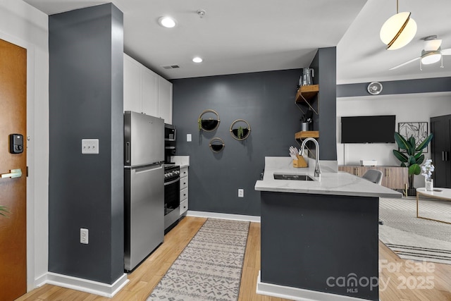 715 N Church St Unit 503, Charlotte, NC 28202 - kitchen with visible vents, a sink, stainless steel appliances, a peninsula, and white cabinets