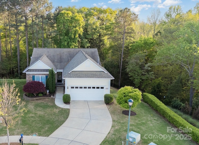 single story home featuring a front yard, a shingled roof, a wooded view, a garage, and driveway