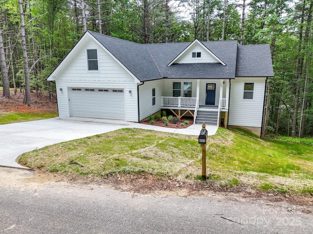 605 Knob Rd, Pisgah Forest, NC 28768 - view of front of house with covered porch, roof with shingles, a garage, concrete driveway, and a front lawn